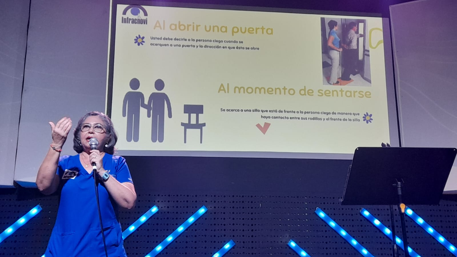 Capacitación a estudiantes de la Escuela Gran Comisión sobre discapacidad visual, con participantes sentados alrededor de una mesa, atentos a la presentación y materiales educativos.