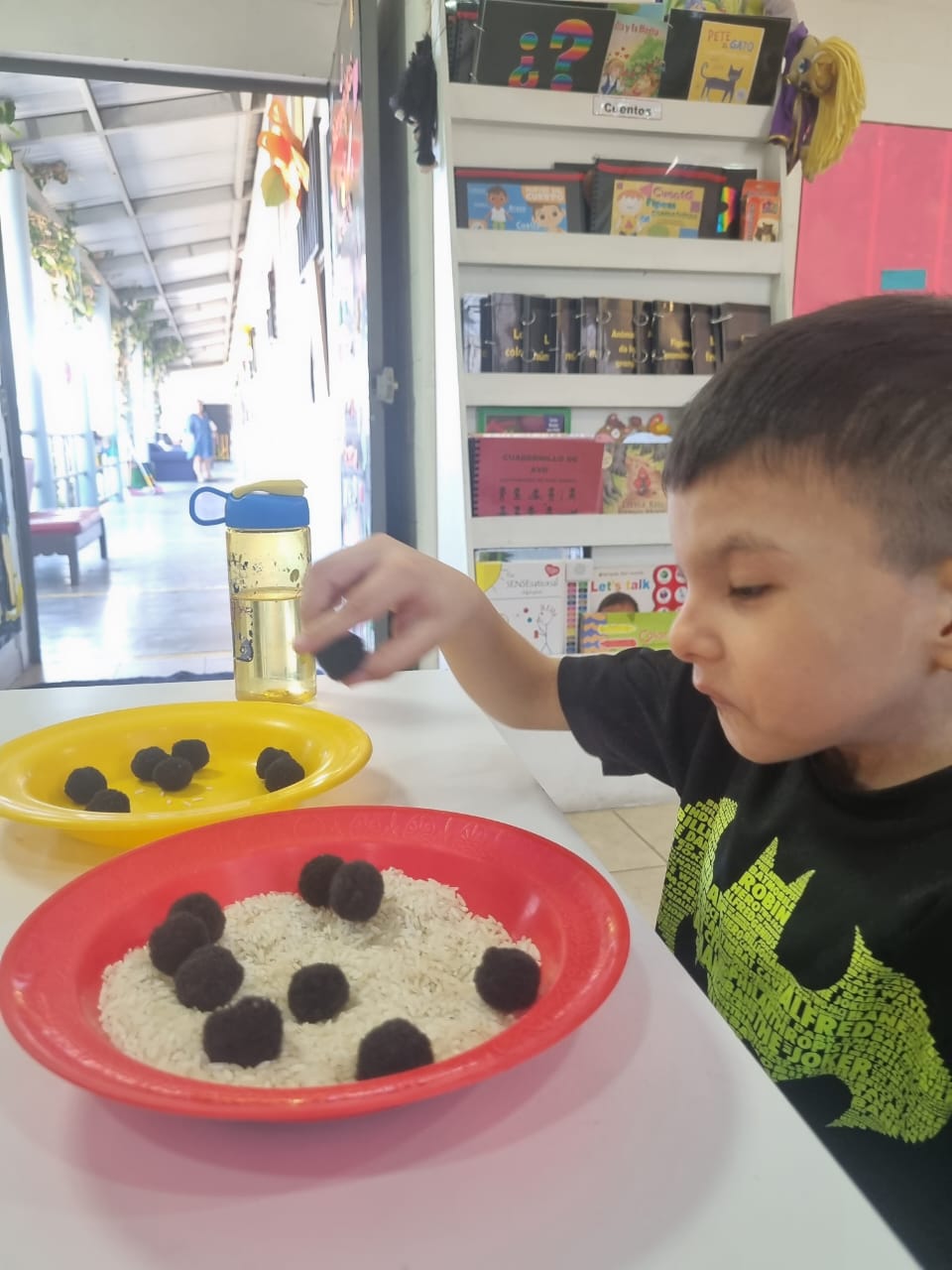 Niño participando en una actividad de estimulación visual, utilizando contrastes y colores brillantes para captar la atención y desarrollar habilidades visuales